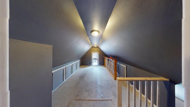 bonus room with carpet flooring, lofted ceiling, and a textured ceiling