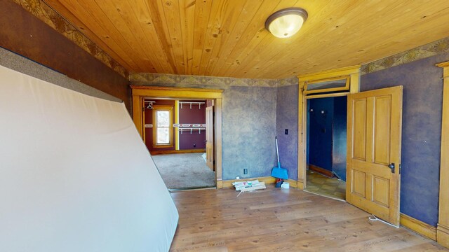 interior space featuring wooden ceiling, baseboards, and wood finished floors