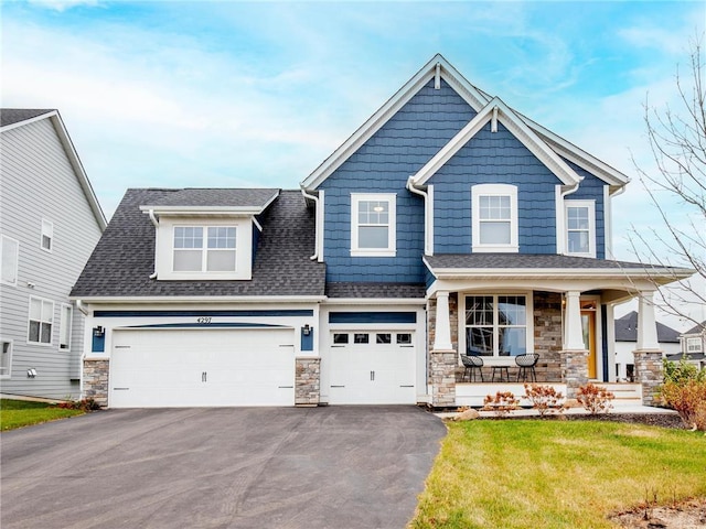 craftsman-style house featuring aphalt driveway, stone siding, and a porch