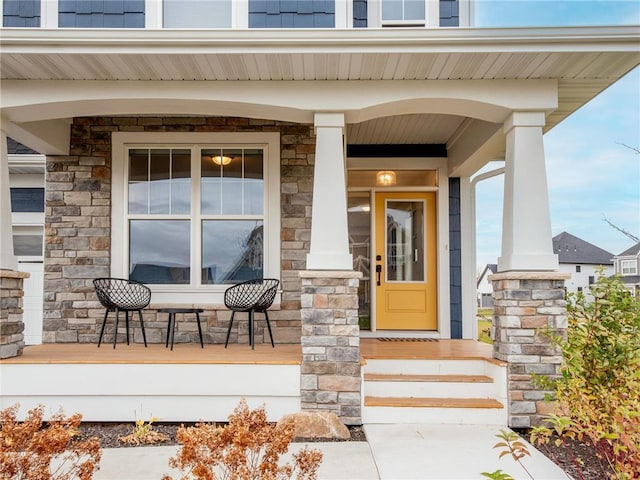 entrance to property with stone siding and a porch