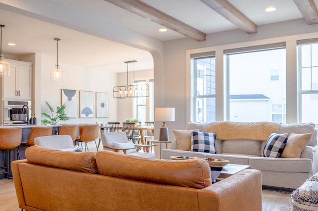 living area with light wood finished floors, beamed ceiling, recessed lighting, and a chandelier