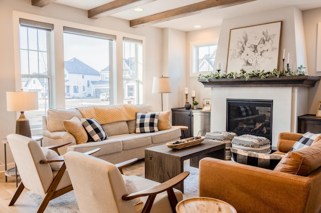 living area with a glass covered fireplace, beamed ceiling, recessed lighting, and light wood-style floors