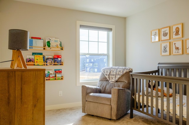 carpeted bedroom with baseboards and a nursery area