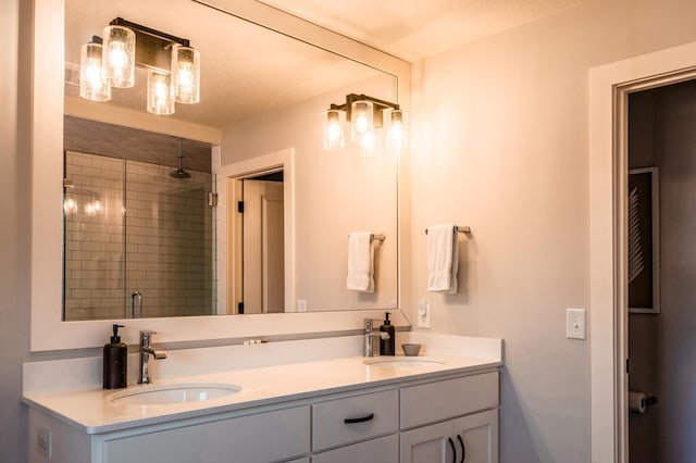 bathroom featuring a textured ceiling, a shower stall, double vanity, and a sink