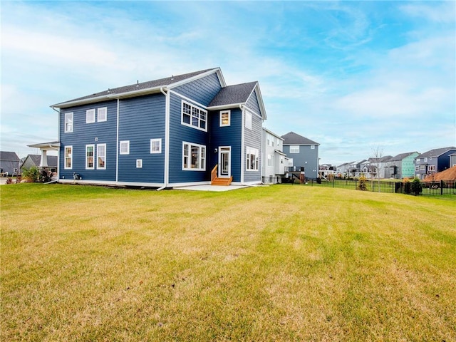 rear view of property with a patio area, a yard, fence, and a residential view