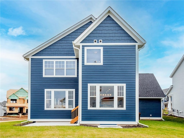 rear view of property featuring a lawn