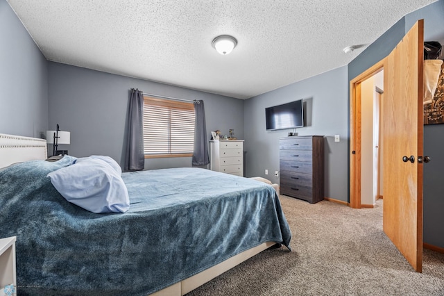 carpeted bedroom featuring baseboards and a textured ceiling