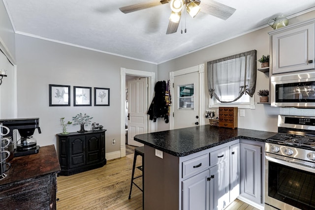 kitchen with ornamental molding, stainless steel appliances, a peninsula, a breakfast bar area, and light wood finished floors