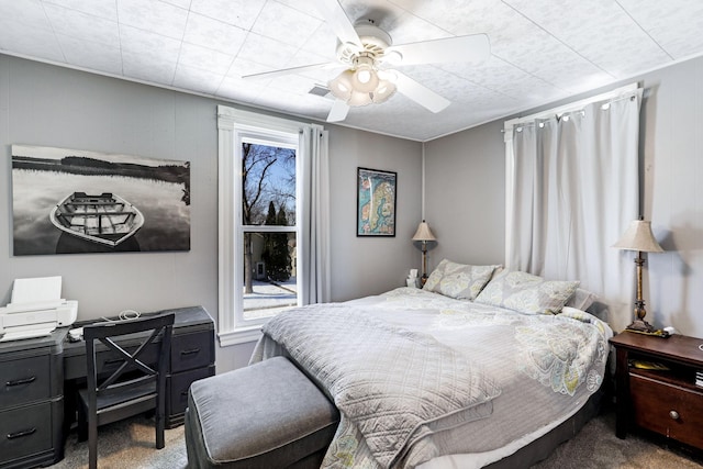 carpeted bedroom featuring multiple windows and ceiling fan