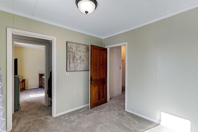 unfurnished bedroom with ornamental molding, baseboards, and light carpet