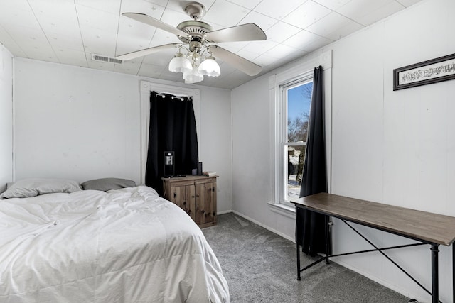 carpeted bedroom featuring visible vents, multiple windows, and a ceiling fan