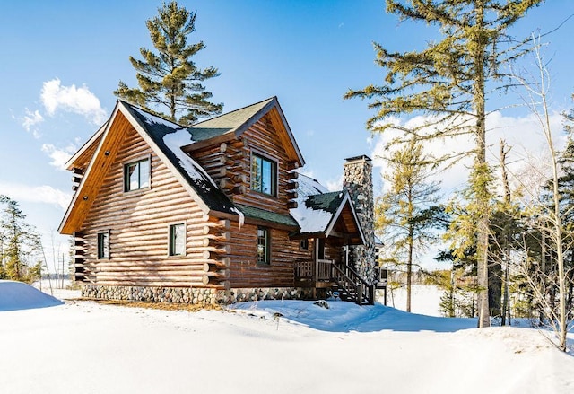 exterior space with log siding and a chimney