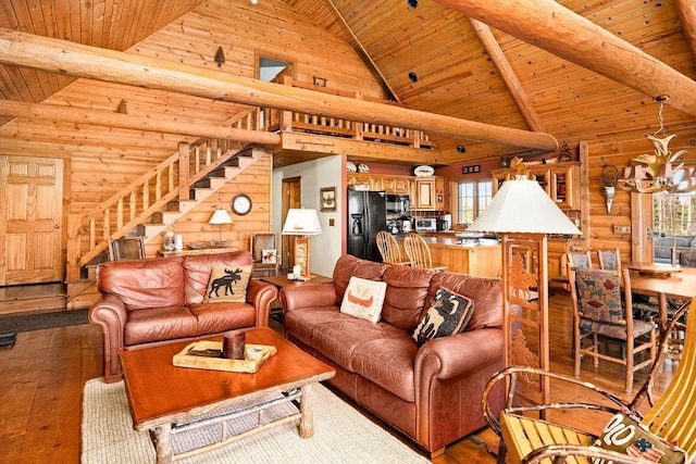 living room featuring beam ceiling, hardwood / wood-style flooring, plenty of natural light, stairway, and wooden ceiling