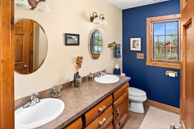 bathroom featuring a sink, toilet, double vanity, and tile patterned flooring