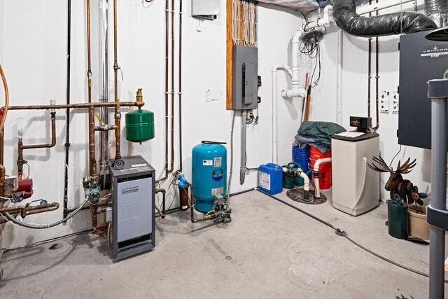 utility room featuring electric panel and a heating unit