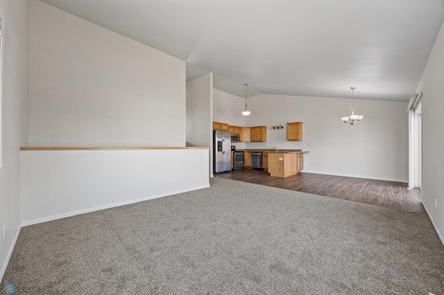 unfurnished living room with baseboards, a chandelier, dark carpet, high vaulted ceiling, and a sink