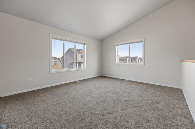 unfurnished room featuring baseboards, carpet, and vaulted ceiling