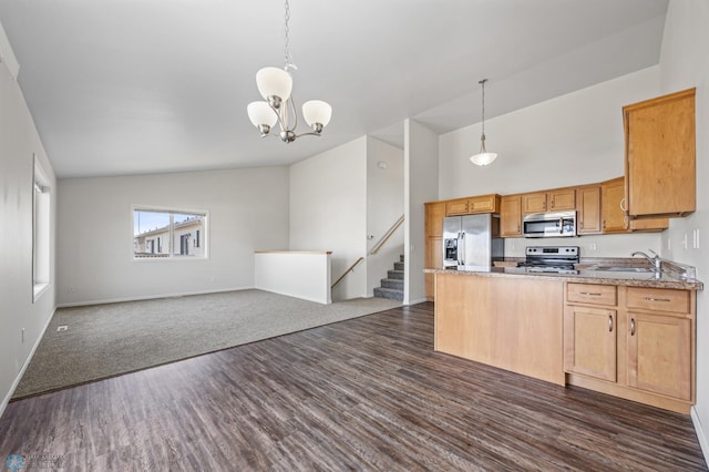 kitchen with open floor plan, pendant lighting, a peninsula, stainless steel appliances, and a sink