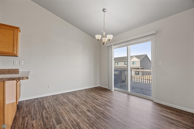 unfurnished dining area with baseboards, a notable chandelier, dark wood-style flooring, and vaulted ceiling