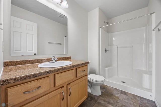 bathroom featuring vanity, toilet, visible vents, and walk in shower