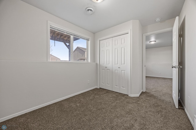 unfurnished bedroom featuring a closet, baseboards, and carpet