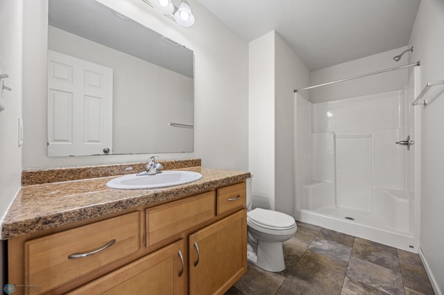 bathroom featuring vanity, toilet, a shower, and stone finish flooring