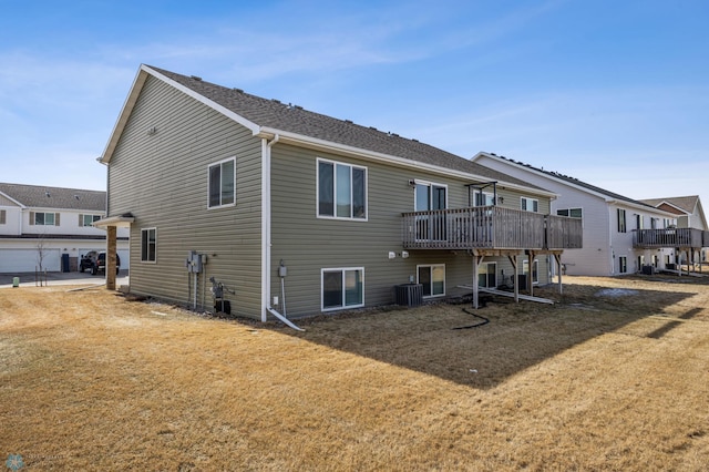 rear view of house featuring cooling unit, a yard, and a wooden deck