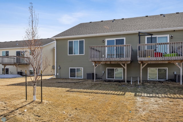 rear view of property with a lawn and a shingled roof