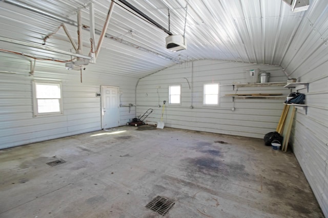 garage with a garage door opener and metal wall