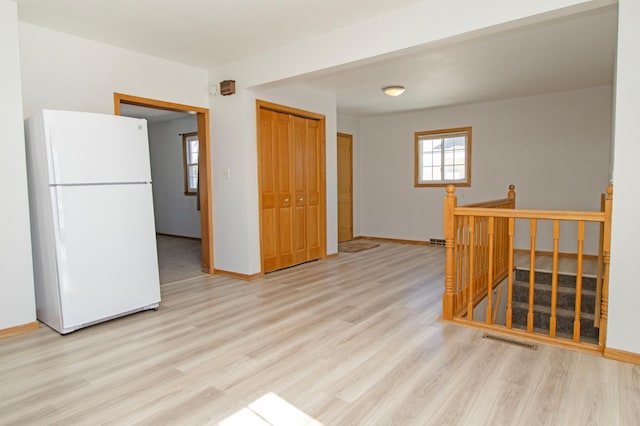 interior space with visible vents, light wood-style flooring, and baseboards