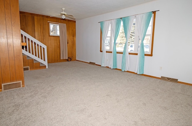 unfurnished room featuring stairs, plenty of natural light, and visible vents