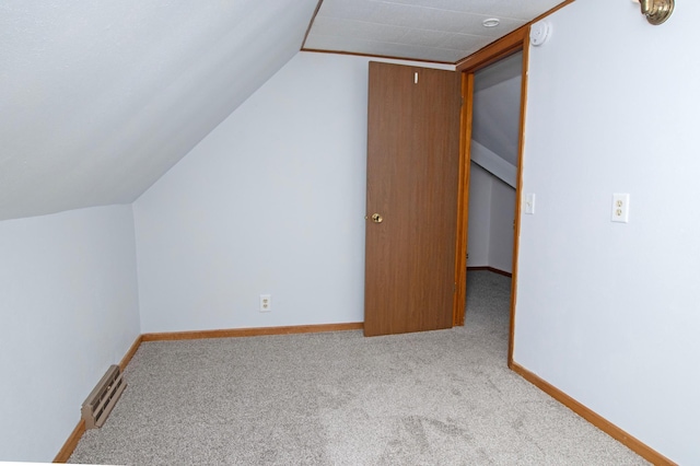 additional living space featuring carpet flooring, baseboards, lofted ceiling, and visible vents