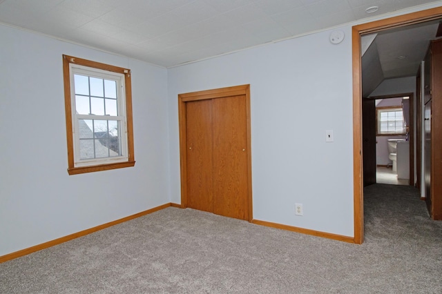 unfurnished bedroom with a closet, carpet flooring, and baseboards