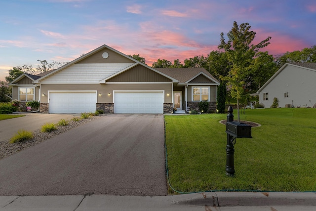 view of front of home with a front yard, a garage, stone siding, and aphalt driveway