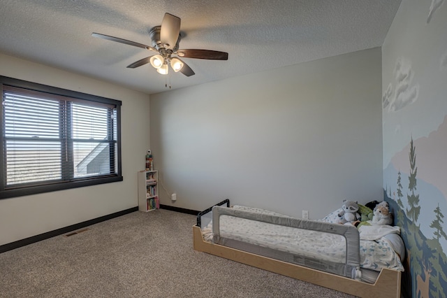 carpeted bedroom featuring visible vents, ceiling fan, a textured ceiling, and baseboards