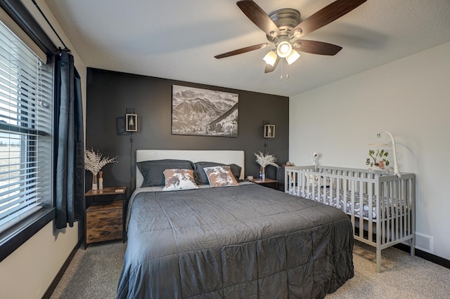 carpeted bedroom featuring a ceiling fan, visible vents, and baseboards