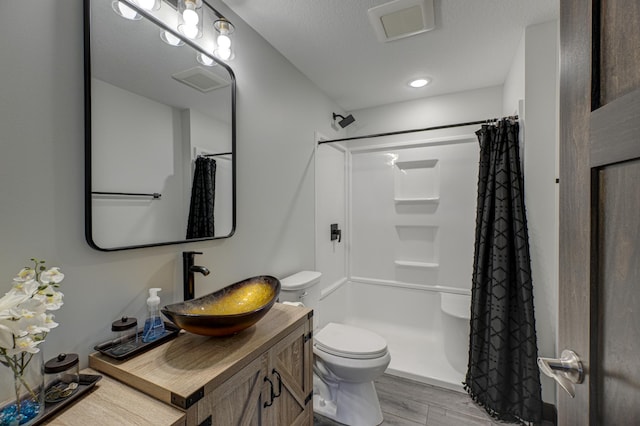 bathroom featuring vanity, wood finished floors, visible vents, curtained shower, and toilet