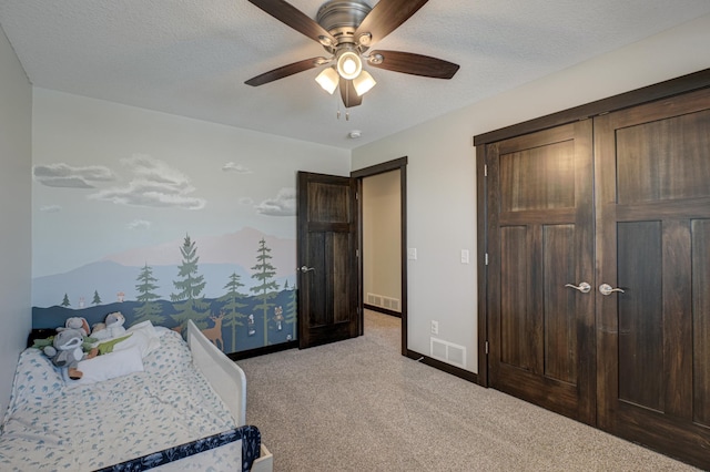 bedroom featuring baseboards, a textured ceiling, visible vents, and light colored carpet