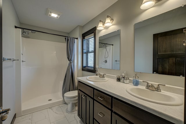 full bathroom with marble finish floor, a shower with shower curtain, toilet, and a sink
