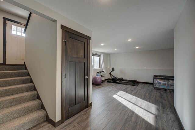 workout room featuring recessed lighting, baseboards, and wood finished floors