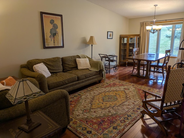 living room with dark wood finished floors and a notable chandelier