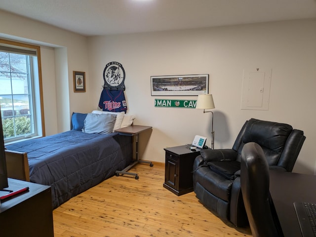 bedroom with light wood-style flooring and electric panel