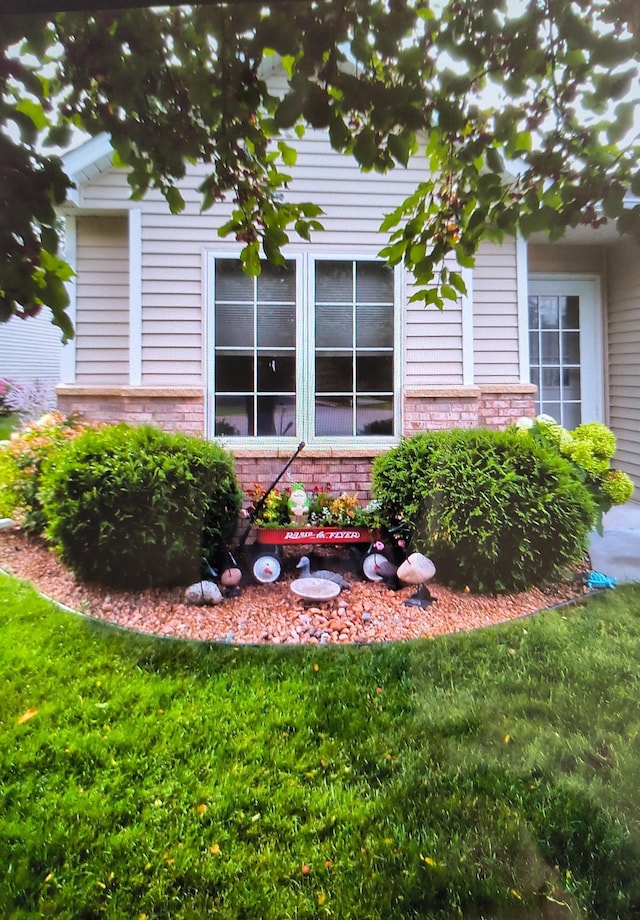 view of property exterior featuring a yard and brick siding