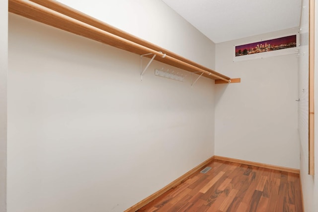 walk in closet with visible vents and wood finished floors