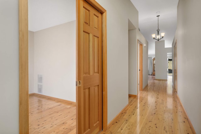 3605 Zinnia Ln N, Plymouth, MN 55441 - hallway featuring light wood finished floors, a chandelier, baseboards, and visible vents