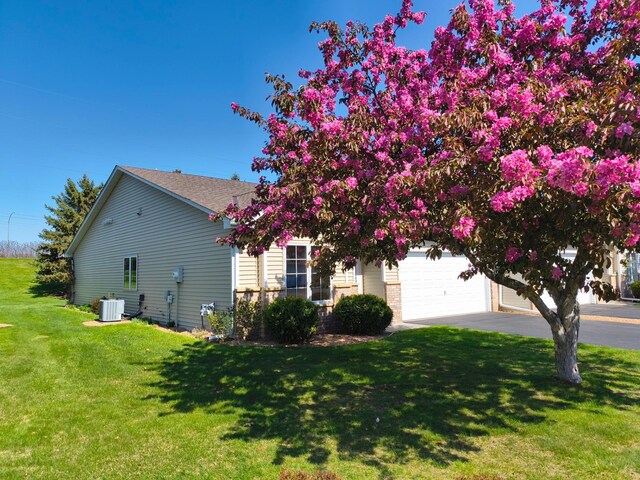 3605 Zinnia Ln N, Plymouth, MN 55441 - view of side of home with cooling unit, driveway, an attached garage, and a lawn