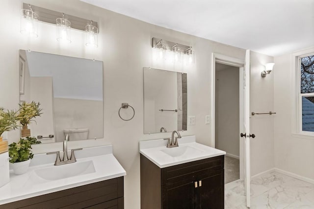 bathroom with a sink, baseboards, marble finish floor, and two vanities