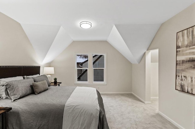 bedroom featuring baseboards, light carpet, and vaulted ceiling