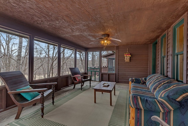 sunroom featuring ceiling fan and an outdoor living space