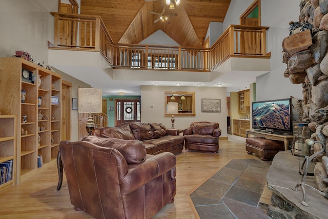 living area with light wood-style floors, wooden ceiling, a ceiling fan, and high vaulted ceiling